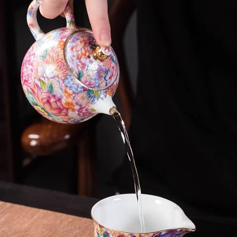 Water pouring from teapot into cup