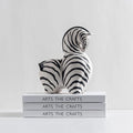 Zebra ornament sat on stack of books