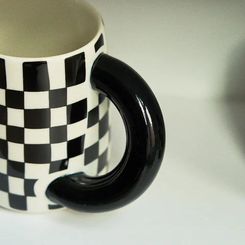 Close up of thick handle of checked mug