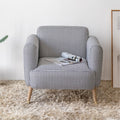 Padded chair in living room with magazine.