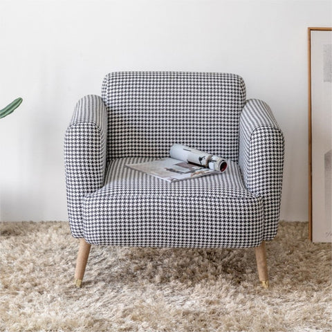 Padded chair in living room with magazine.