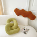 Selection of abstract-shaped pillows on sofa.