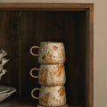 stacked mugs and coaster in cupboard