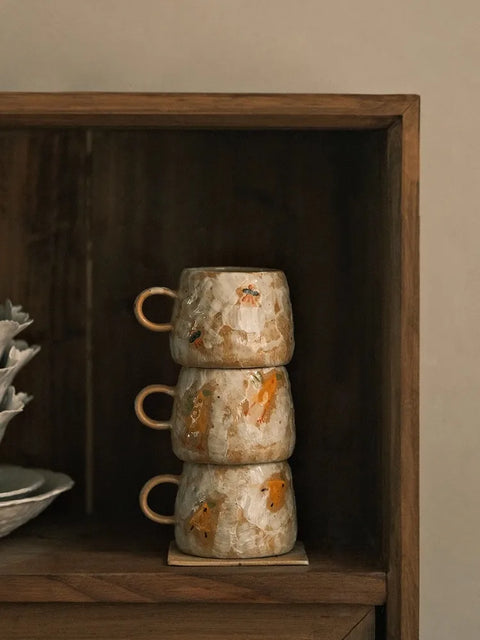 stacked mugs and coaster in cupboard