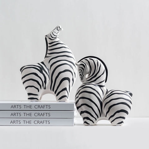 2 zebra ornaments sat on stack of books