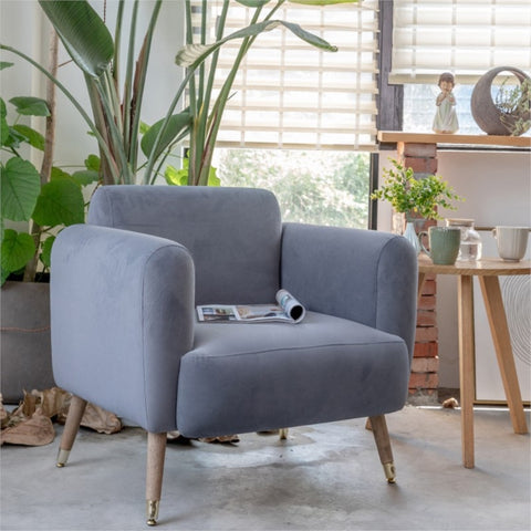 Padded chair in living room with magazine.