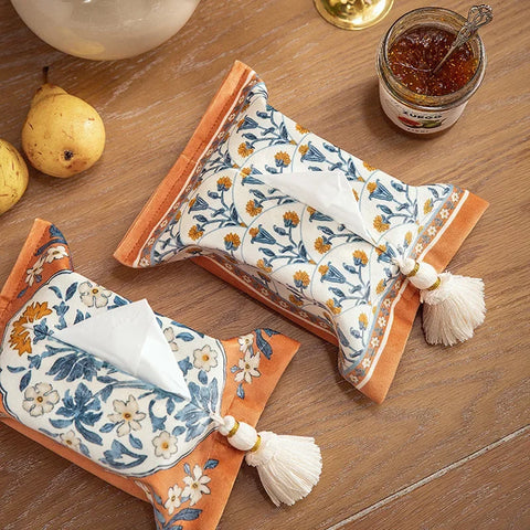 Two woven tissue boxes on table next to food