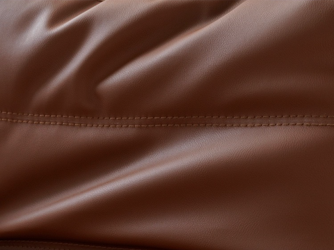 Close up of leather-look slouch couch chair.