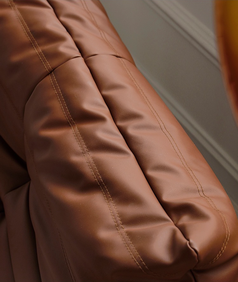 Close up of leather-look slouch couch chair.