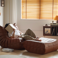 Leather-look slouch couch chair with matching foot stool.