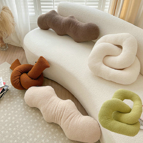 Selection of abstract-shaped pillows on sofa.